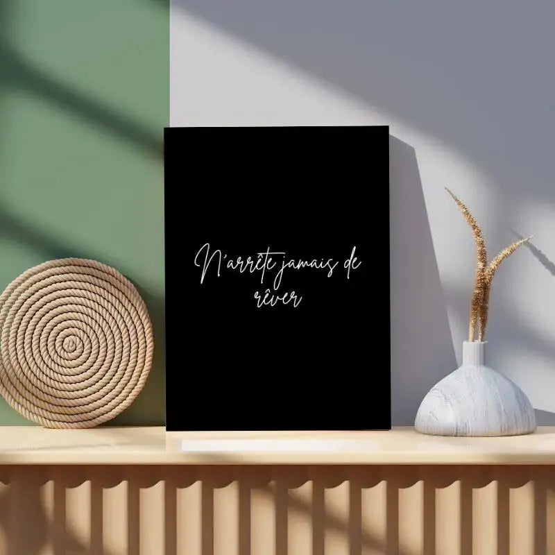 Tableau noir et blanc avec la citation "N'arrête jamais de rêver", message inspirant au style moderne et minimaliste