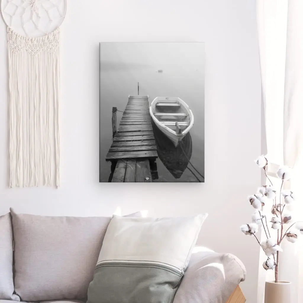 Tableau noir et blanc représentant un ponton avec une barque sur un lac, scène paisible et contemplative