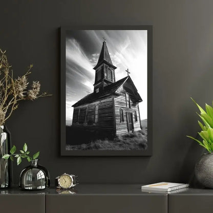 Un tableau encadré représentant une ancienne église rustique en bois est accroché sur un mur sombre. À proximité se trouvent diverses décorations, notamment des plantes, un bocal en verre et une montre sur la table.