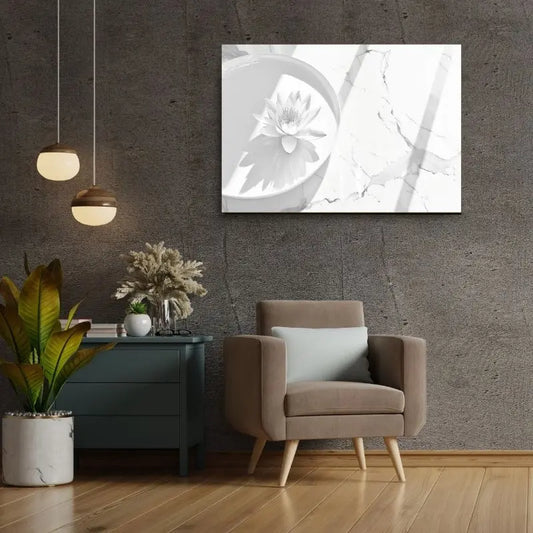 Salon moderne avec un fauteuil gris, une table d'appoint verte, des plantes en pot et le Tableau Zen Lotus Blanc et Gris encadré sur un mur gris texturé. Deux luminaires suspendus sont visibles au-dessus de la table d'appoint, ajoutant au décor zen.