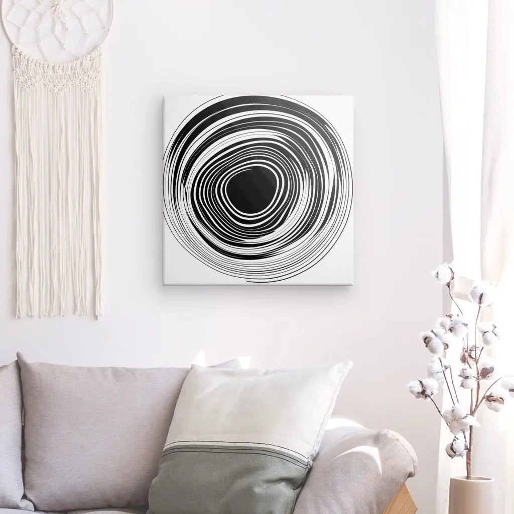 Tableau Noir et Blanc Minimaliste Cercle Vinyle Abstrait Monochrome accroché à un mur au-dessus d'un canapé gris avec des oreillers, à côté d'un rideau blanc et d'un arrangement floral.