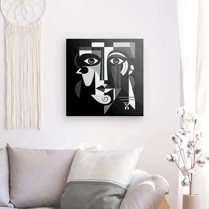 Un Tableau Portrait Cubisme Noir Art Abstrait Noir et Blanc est accroché sur un mur blanc au-dessus d'un canapé gris clair avec un oreiller blanc et gris. Un cotonnier et une tenture murale tissée sont également visibles.