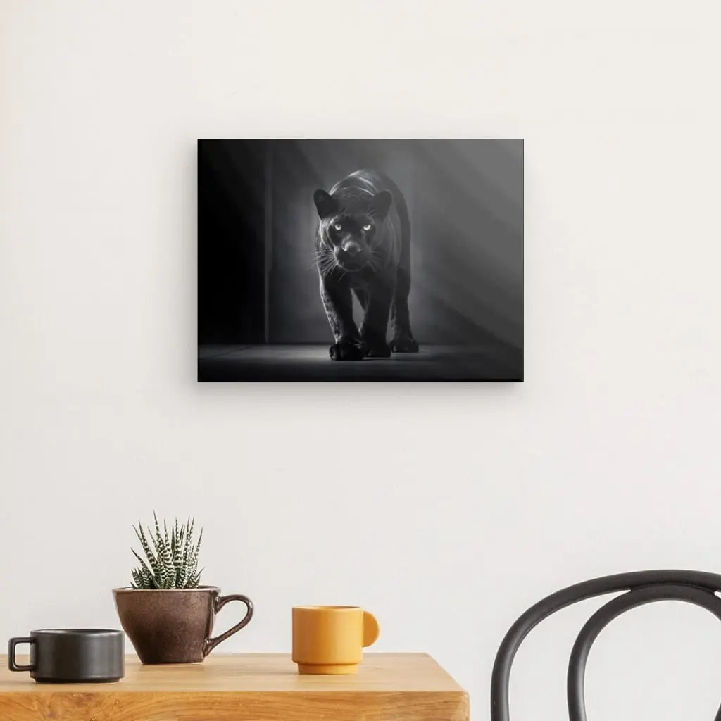 Un Tableau Panthère Noire Félin Animal Sauvage Noir et Blanc monté comme une œuvre d'art au-dessus d'une table avec des plantes succulentes en pot, une tasse et une chaise.