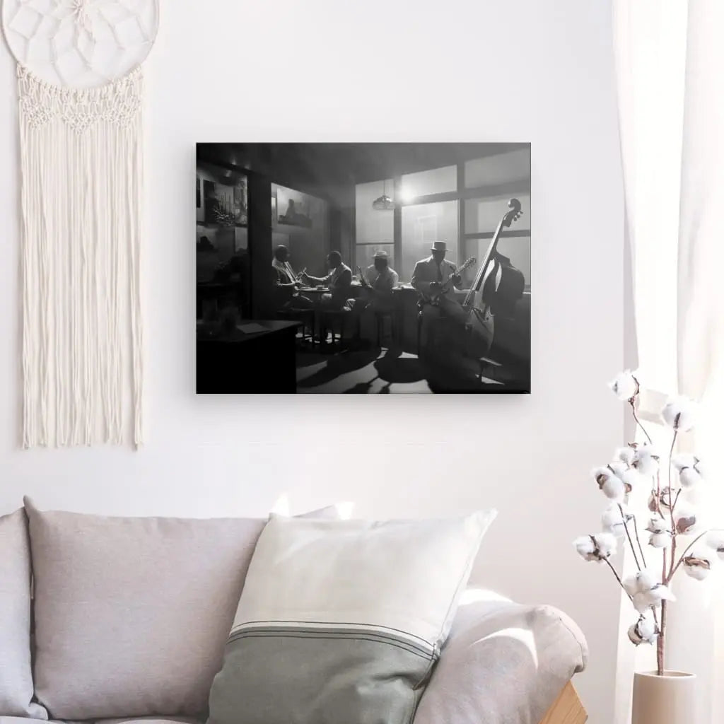 Un Tableau Scène de Jazz Club Violoncelle Noir et Blanc encadré est accroché sur un mur blanc au-dessus d'un canapé blanc avec un oreiller gris clair. Une plante aux tiges de coton blanc est positionnée à côté du canapé, créant un subtil contraste artistique.