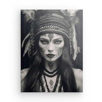 Photo en noir et blanc d'une personne au visage peint, portant une coiffe et des colliers de perles, regardant directement l'appareil photo : un véritable Tableau Femme Indienne Portrait Noir et Blanc qui capture une élégance intemporelle.