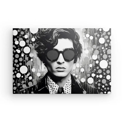 Illustration en noir et blanc d'une personne aux cheveux ondulés portant de grandes lunettes de soleil rondes et une chemise à pois, entourée de motifs circulaires abstraits, créant un Tableau Homme Pop Art Bulles Noir et Blanc débordant d'esthétique de l'art moderne.