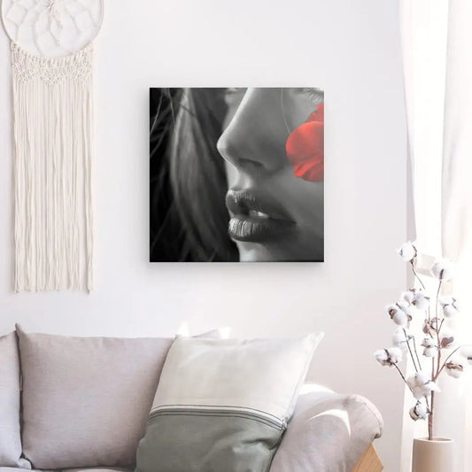 Tableau noir et blanc Portrait Femme Noir et Blanc Fleur Rouge d'un visage de femme avec une fleur rouge, imprimé sur une toile blanc brillant à texture fine, dans un décor de salon moderne.