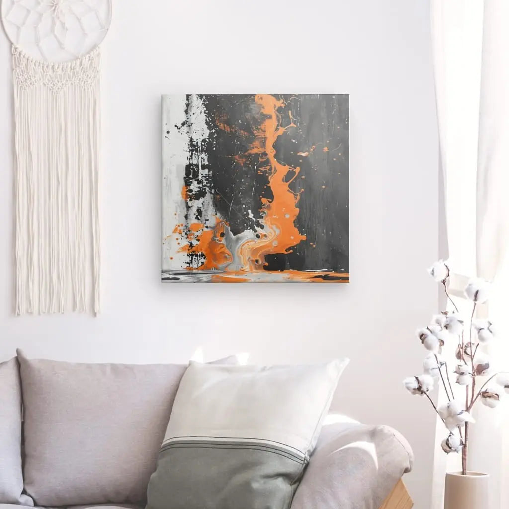 Un salon minimaliste avec un canapé gris, un oreiller blanc, un tableau mural *Tableau Abstrait Noir et Blanc Touche d'Orange* et une tenture murale tissée. La lumière naturelle est filtrée à travers un rideau blanc.