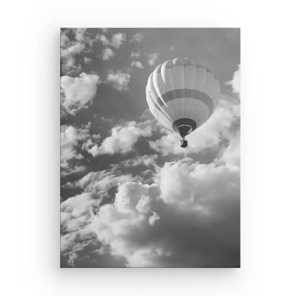 Un Tableau Montgolfière Ballon Noir et Blanc flotte parmi les nuages épars dans un ciel monochromatique, créant un superbe tableau noir et blanc qui sert d'œuvre d'art intérieur exquise.