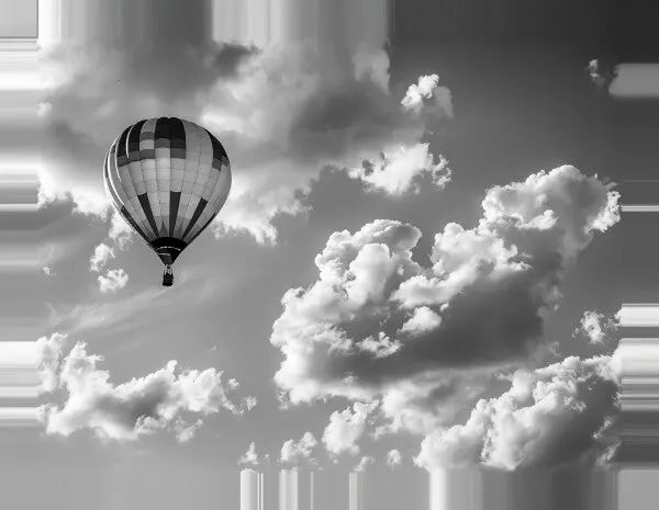 Image en noir et blanc d'un Tableau Montgolfière Aérostat Paysage Ciel Noir et Blanc planant parmi de gros nuages duveteux dans le ciel, créant un paysage aérien fascinant.