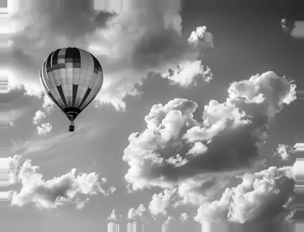 Un Tableau Montgolfière Aérostat Paysage Ciel Noir et Blanc flotte parmi les nuages épars dans un tableau noir et blanc, créant un paysage aérien serein.