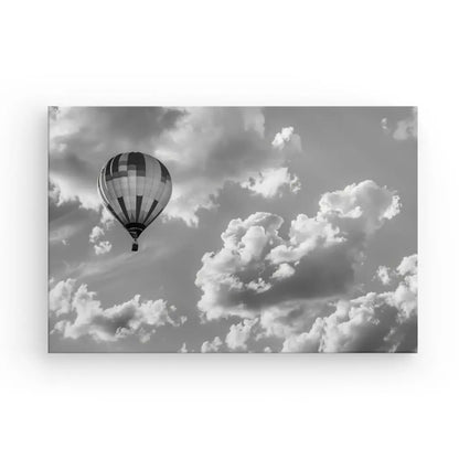 Un Tableau Montgolfière Aérostat Paysage Ciel Noir et Blanc capture une montgolfière flottant sereinement parmi les nuages épars, créant un paysage aérien fascinant dans le ciel.