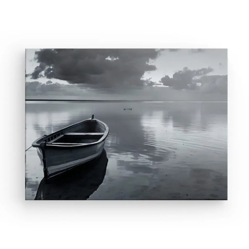 Un Tableau Barque Lac Paisible Noir et Blanc solitaire flotte sur des eaux calmes et réfléchissantes sous un ciel couvert, créant un tableau noir et blanc avec des nuages lointains et un horizon serein en arrière-plan.