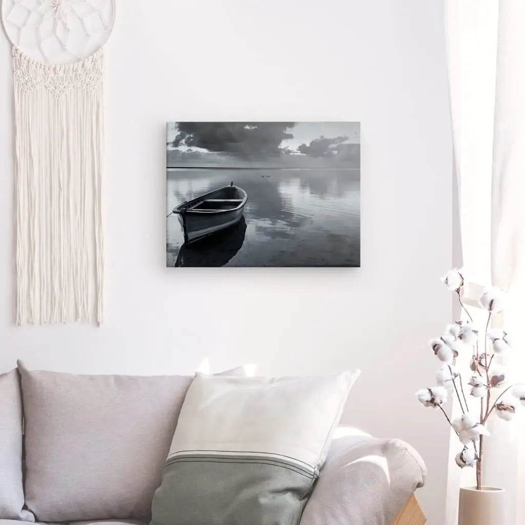 Un salon minimaliste avec un canapé blanc, un Tableau Barque Lac Paisible Noir et Blanc au mur, une tenture murale en macramé et une décoration en cotonnier.