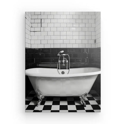 Une salle de bain en noir et blanc avec une superbe baignoire sur pattes, des carreaux de métro blancs et noirs sur le mur et un Tableau Salle de Bain Baignoire Noir et Blanc créent le tableau noir et blanc parfait pour votre spa à domicile.