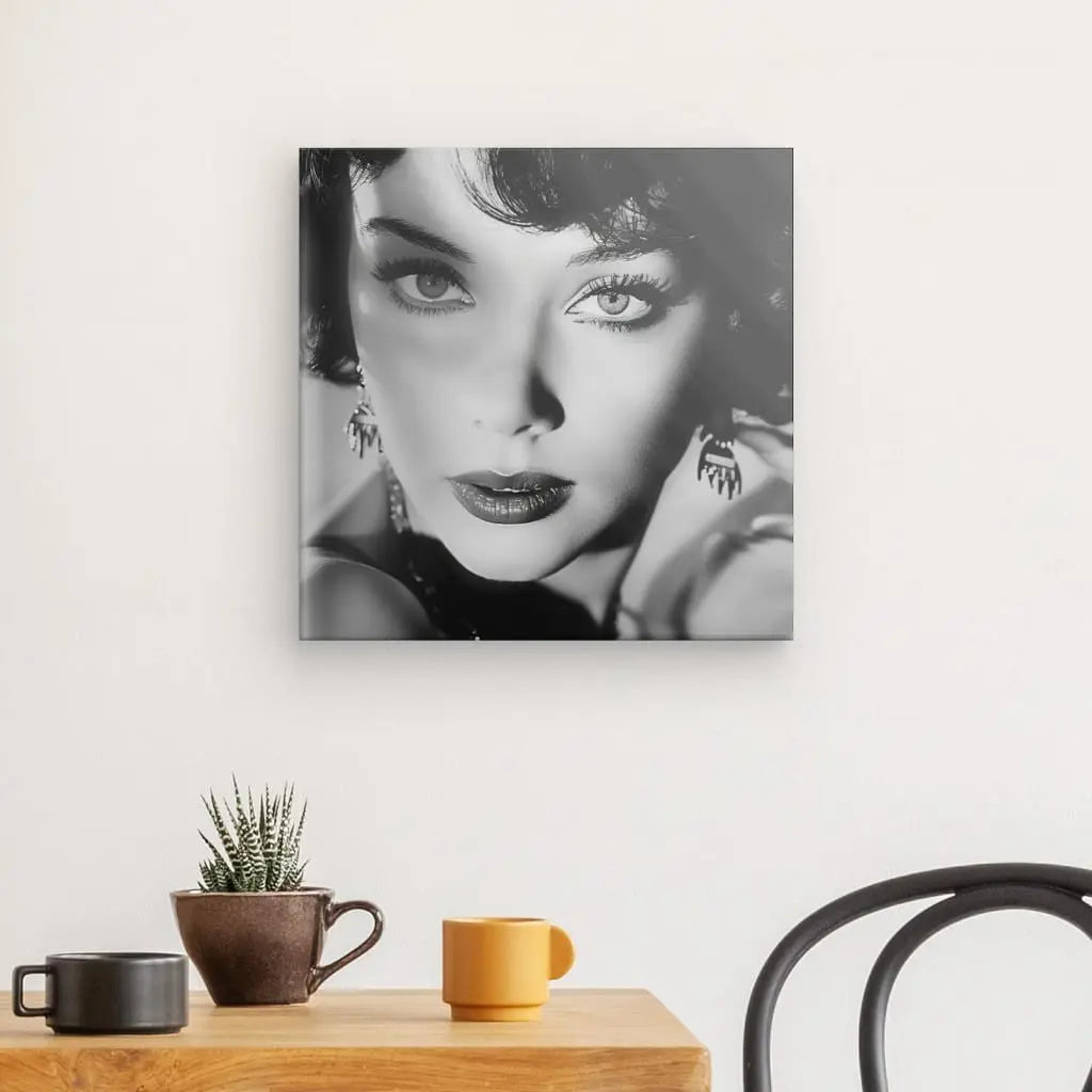 Un portrait de femme en noir et blanc, rappelant le Tableau Actrice Célèbre Rétro Noir et Blanc, est encadré au mur au-dessus d'une table en bois avec une plante en pot et deux mugs. Une chaise noire est partiellement visible à droite.