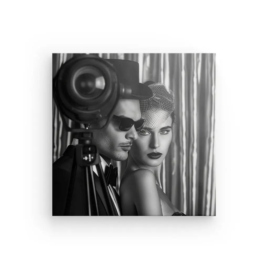 Un homme portant des lunettes de soleil et une femme portant un casque en filet posent ensemble devant une caméra rétro. L'image en noir et blanc, qui n'est pas sans rappeler Tableau Photo Mannequin Rétro Studio Noir et Blanc, dégage une atmosphère hollywoodienne vintage.