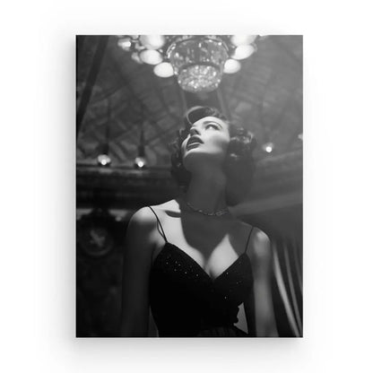 Dans ce Tableau Portrait Diva Femme 50's Luxe Noir et Blanc, une femme vêtue d'une robe sombre prend la pose d'une diva, levant les yeux avec un air d'élégance. Le lustre et le plafond orné évoquent l'atmosphère luxueuse des années 50, ajoutant un charme intemporel à cette image captivante de Femme.