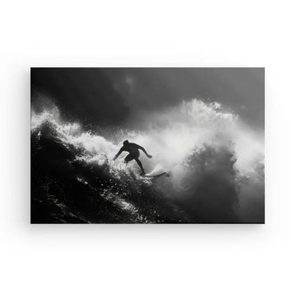 Image en noir et blanc d'un surfeur intrépide surfant sur une grosse vague, avec de l'eau éclaboussant tout autour. La personne est en équilibre sur une planche de surf au milieu d'un mouvement dynamique, capturé dans ce magnifique Tableau Surf Océan Noir et Blanc.