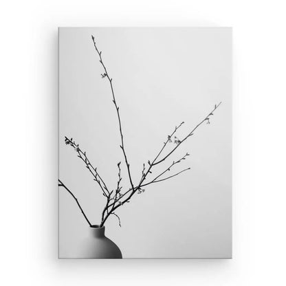 Photo en noir et blanc d'un arrangement minimaliste de fines branches dans un vase simple, créant un élégant Tableau Nature Morte Pot Plante Branches Noir et Blanc sur un fond uni.