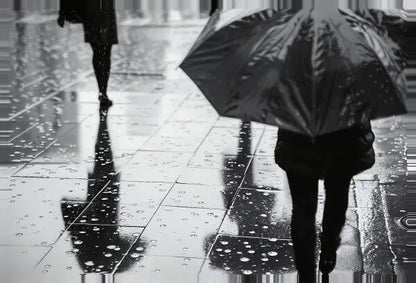 Deux personnes marchant sur un trottoir mouillé, l'une portant un parapluie, dans cette saisissante scène du Tableau Pluie Parapluie Urbaine Noir et Blanc. Leurs reflets sont visibles dans les flaques d'eau au sol, évoquant un tableau noir et blanc.