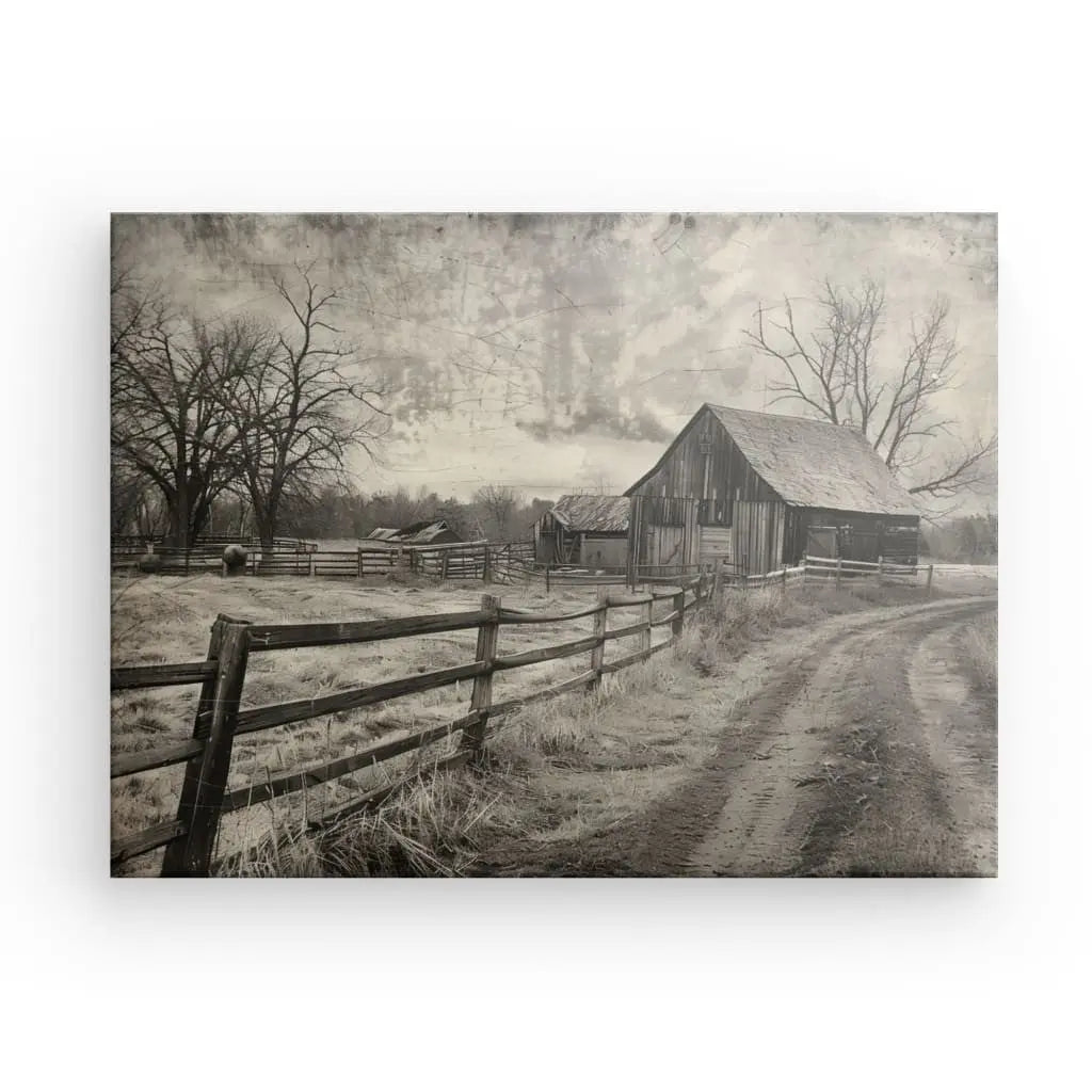 Photo en noir et blanc d'une vieille grange et d'un chemin de terre clôturé dans une ferme rurale, avec des arbres sans feuilles et un ciel nuageux en arrière-plan, créant une ambiance Tableau Paysage Campagne Ancien Noir et Blanc.