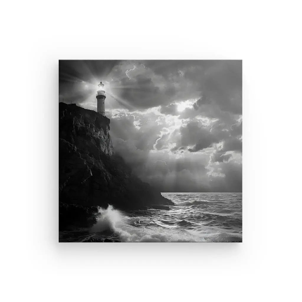 Cette photo en noir et blanc d'un phare sur une falaise, entouré de terrains rocheux et de vagues déferlantes, capture parfaitement l'essence des paysages marins. Le phare émet un faisceau de lumière brillant à travers un ciel nuageux au-dessus de l'océan, créant un élégant Tableau Falaise Phare Breton Atlantique Noir et Blanc.