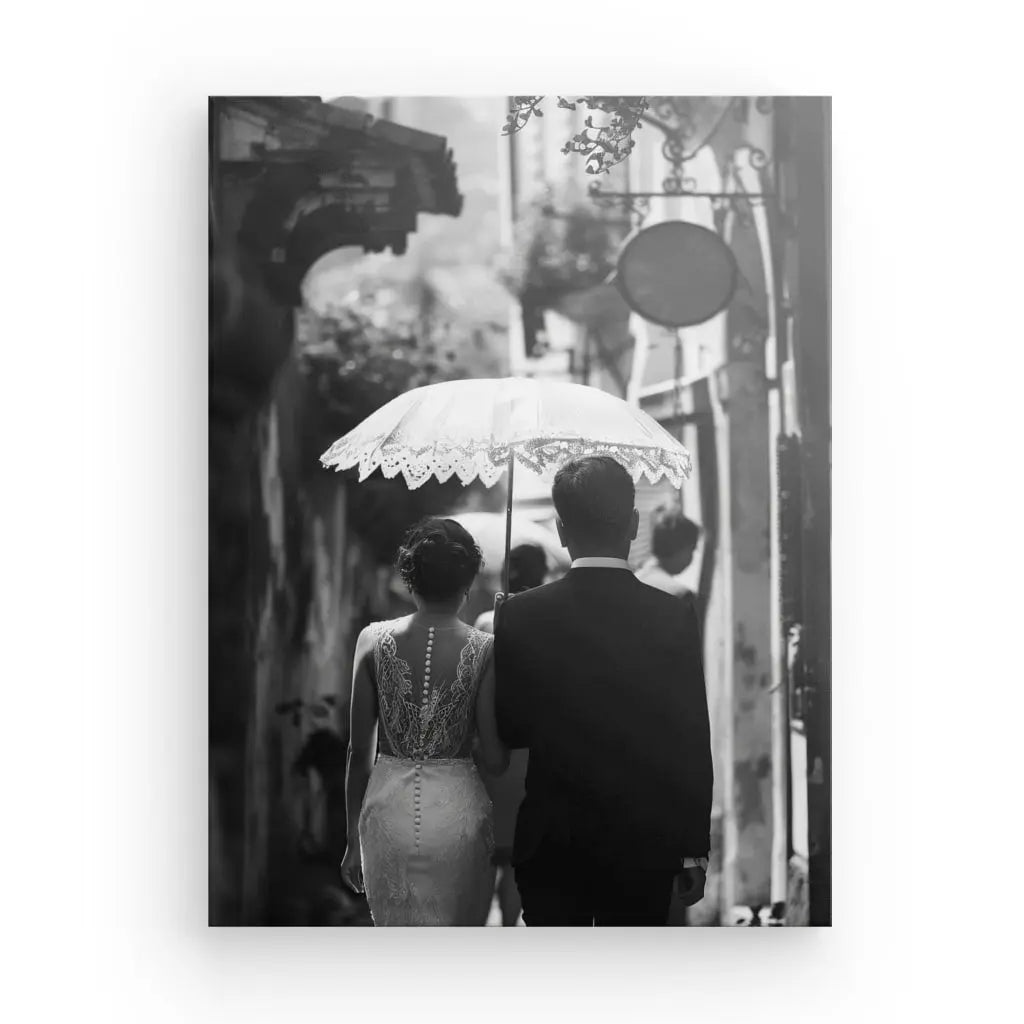 Un couple habillé en tenue formelle marche dans une rue étroite sous un parasol en dentelle, capturé de dos dans "Tableau Mariés Photo de Dos Ombrelle Noir et Blanc", dégageant un air d'art romantique.