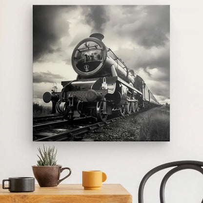 Un Tableau Locomotive Vapeur Noir et Blanc est accroché sur un mur blanc au-dessus d'une table en bois avec une petite plante en pot, une tasse marron et une tasse jaune. Embrassant la décoration industrielle, il y a aussi une chaise noire à côté de la table.