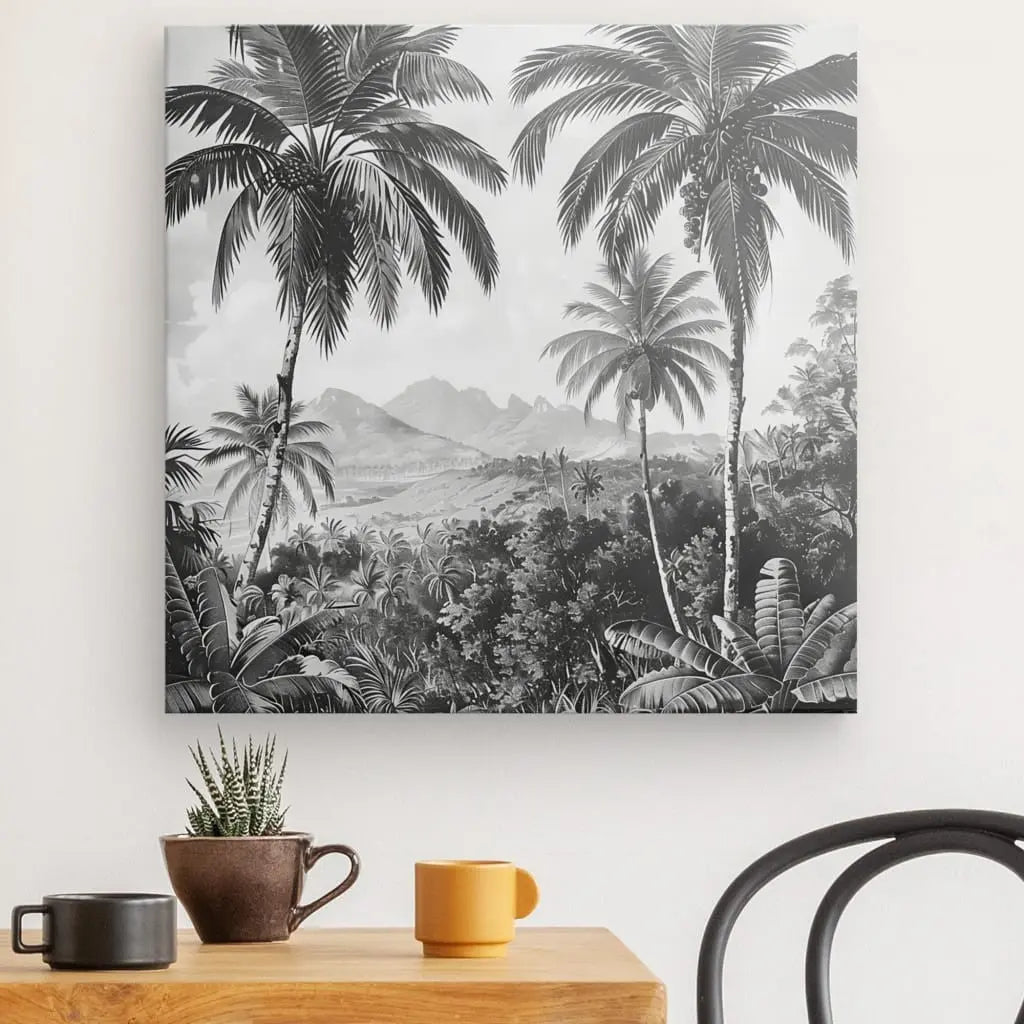 Un Tableau Dessin Peinture Cocotiers Jungle Noir et Blanc est accroché au mur au-dessus d'une table en bois ornée d'une petite plante en pot, de deux tasses et d'une partie de chaise visible, ajoutant un air de décoration exotique.