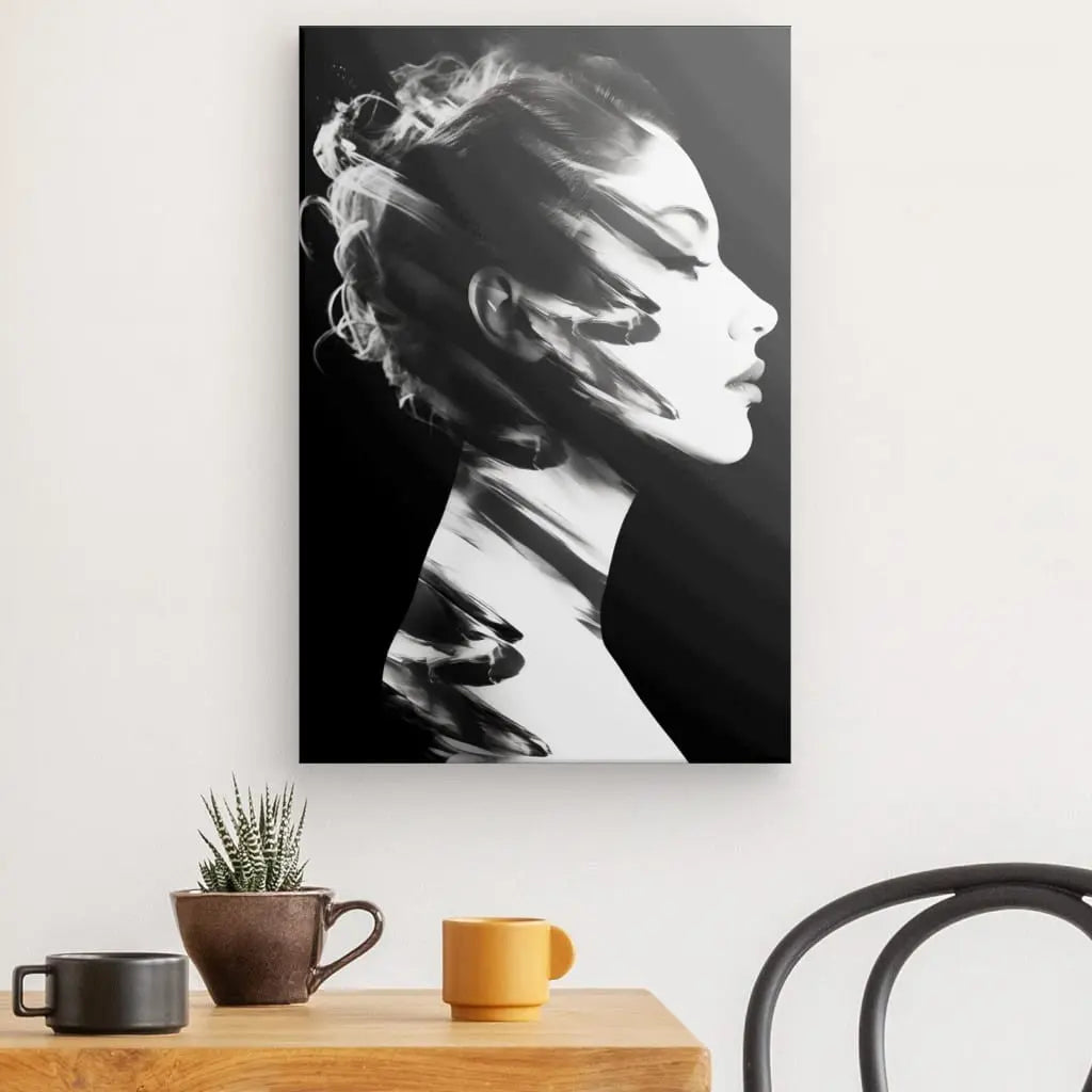 Portrait noir et blanc d'une femme de profil, affiché au mur au-dessus d'une table portant une plante en pot et deux tasses. Ce Tableau Profil Femme Moderne Noir et Blanc apporte une touche d'élégance à la décoration moderne.