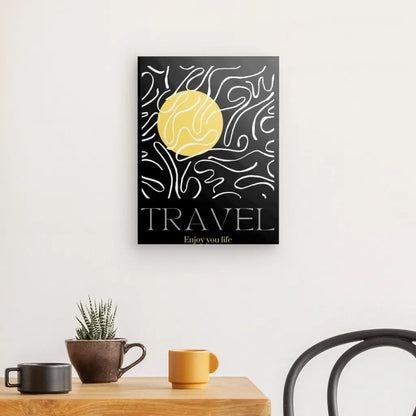 Affiche murale représentant un soleil jaune et des lignes abstraites sur fond noir, intitulée "Tableau 'Travel' Noir Blanc Jaune". Cette décoration artistique est complétée par une table en bois contenant une petite plante en pot et deux tasses, avec une chaise partiellement visible.