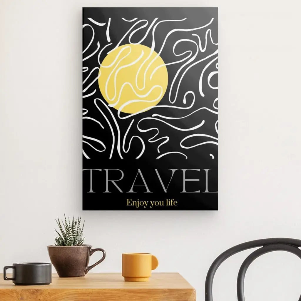 Un Tableau "Travel" Noir Blanc Jaune avec un soleil jaune, des lignes ondulées abstraites et les mots "TRAVEL Enjoy your life". Cette décoration artistique est exposée au-dessus d'une table avec un cactus, une tasse marron et une tasse orange. Le tableau ajoute une touche élégante à tout décor noir et blanc.