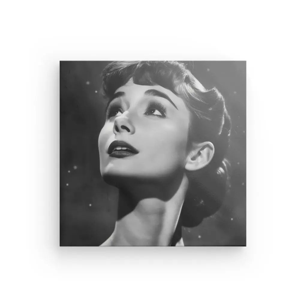 Portrait en noir et blanc d'une femme aux cheveux courts et ondulés regardant vers le haut avec une expression sereine, rappelant un Tableau Audrey Hepburn Noir et Blanc. Le fond est sombre et moucheté de petites lumières faibles, comme celles des toiles de haute qualité.