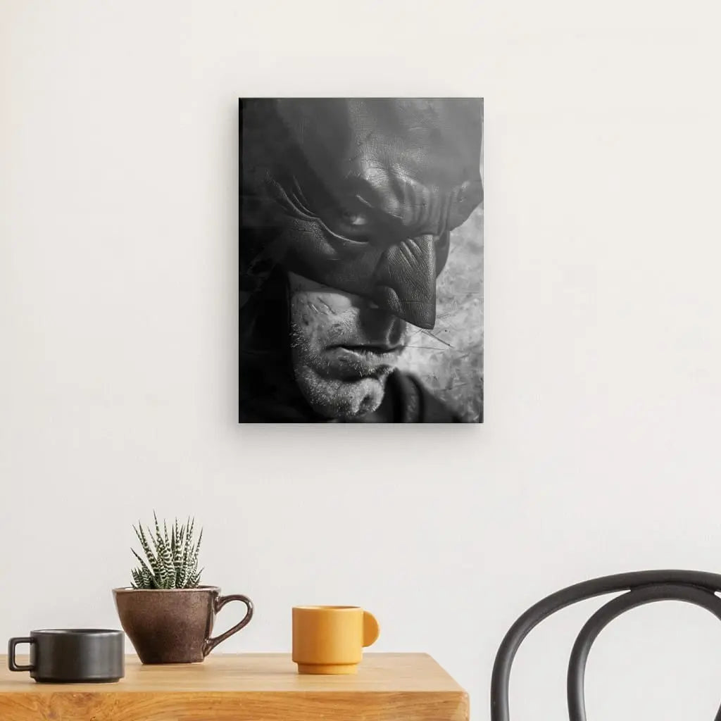 Un Tableau Batman Super Héros Noir et Blanc représentant une figure masquée, rappelant un super héros légendaire, est accroché au mur au-dessus d'une table en bois avec une plante en pot et deux tasses à café, à côté d'une chaise en métal noir.