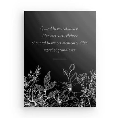 Tableau noir et blanc avec citation sur gratitude et fleurs.