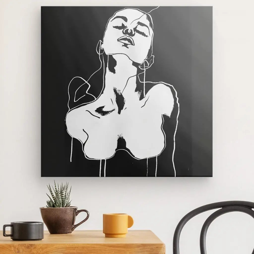 Un dessin minimaliste en noir et blanc intitulé "Tableau Dessin Femme Noir et Blanc Art Moderne" représentant une personne au cou cambré sur fond noir est suspendu au-dessus d'une table en bois ornée de trois tasses et d'une petite plante en pot, incarnant une décoration intérieure élégante.