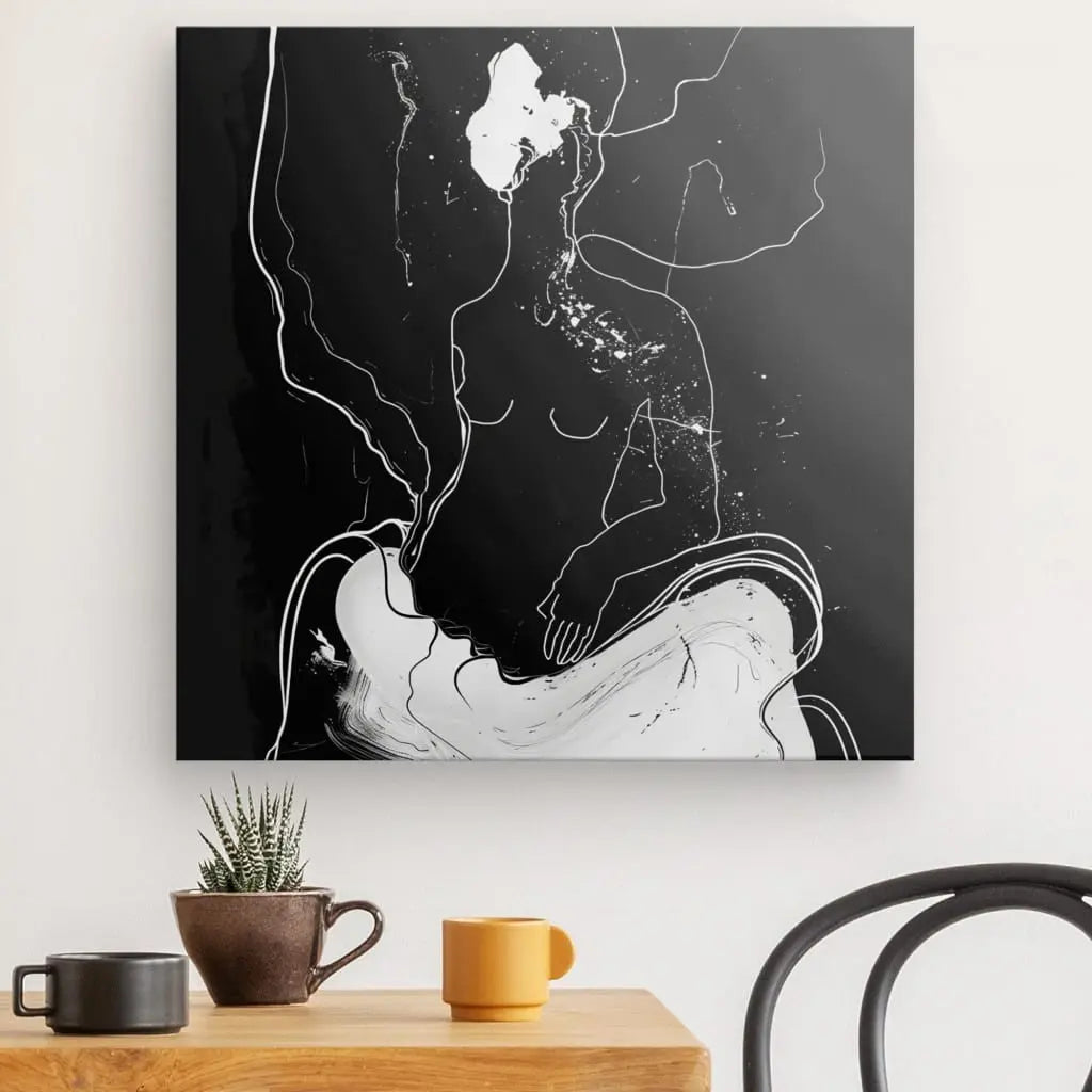 Un Tableau Contemporain Humain Eclosion Abstraite Monochrome minimaliste aux lignes fluides est accroché au-dessus d’une table en bois. Sur la table se trouvent une petite plante verte dans un pot marron et une tasse jaune. Une chaise noire est partiellement visible, ajoutant à la décoration intérieure sophistiquée.