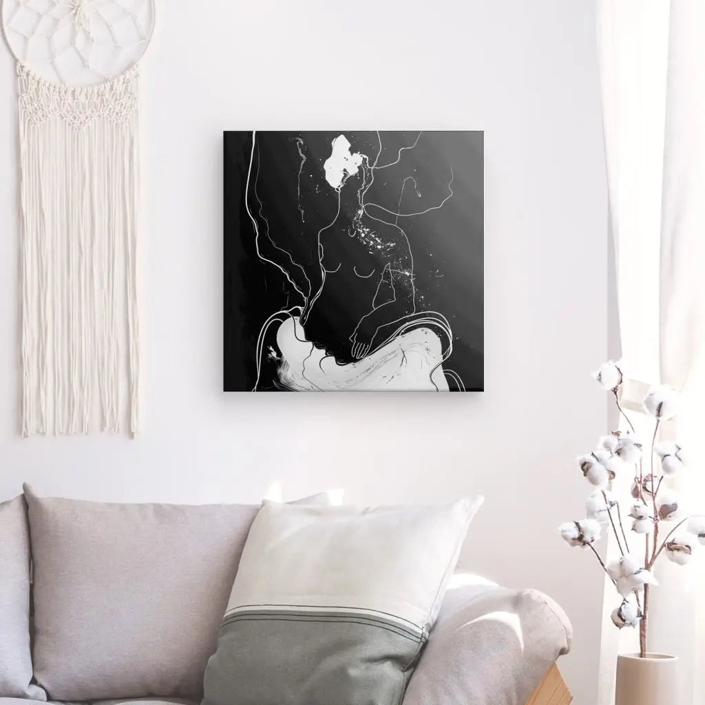 Un salon minimaliste comprend un canapé de couleur claire avec des oreillers blancs et gris, un Tableau Contemporain Humain Eclosion Abstraite Monochrome au mur et un vase avec des branches de coton, créant un élégant tableau abstrait qui rehausse la décoration intérieure.