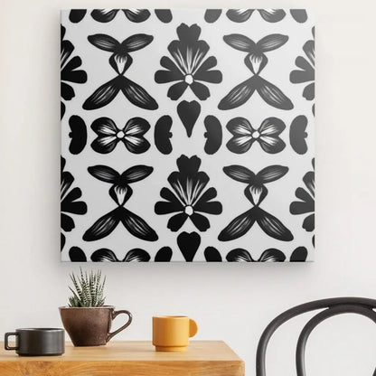 Un mur avec un **Tableau Motifs Ethniques Noir et Blanc** suspendu au-dessus d'une petite table en bois avec deux tasses et une petite plante en pot rehausse la décoration intérieure.