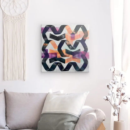 Une peinture abstraite moderne aux formes noires, violettes et orange est accrochée à un mur blanc au-dessus d'un canapé gris avec un oreiller blanc et gris. Le Tableau Formes Géométriques Noir Blanc Touche de Couleur est complété par une tenture murale en macramé et une plante en pot à proximité, créant la décoration moderne parfaite.