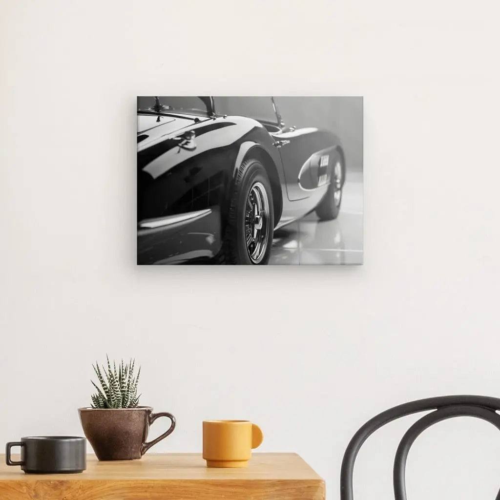 "Tableau Voiture Décapotable Noir et Blanc" encadré affiché sur un mur blanc au-dessus d'une table en bois avec une plante en pot et des tasses.