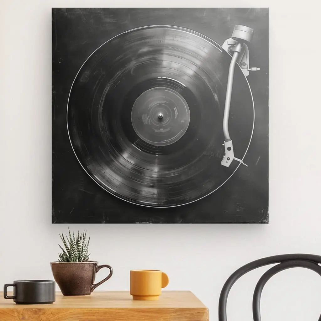 Une décoration intérieure représentant un Tableau Platine Vinyle Minimaliste Noir et Blanc est montée au-dessus d'une table avec une tasse marron, une tasse jaune et une petite plante en pot, à côté d'une chaise noire.