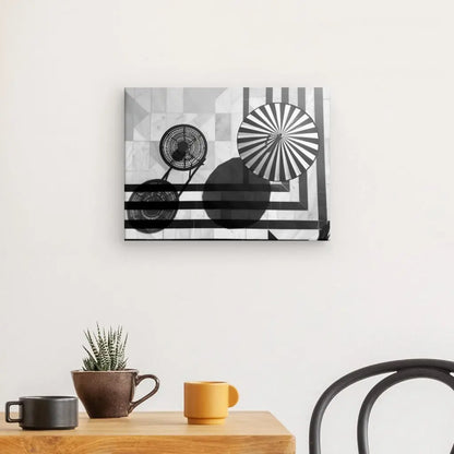 Un intérieur minimaliste composé d'une table en bois avec une petite plante en pot et trois mugs dégage une décoration chic. Le Tableau Bord de Piscine Été Noir et Blanc est monté sur le mur blanc au-dessus d'une chaise noire, renforçant encore l'ambiance relaxante.