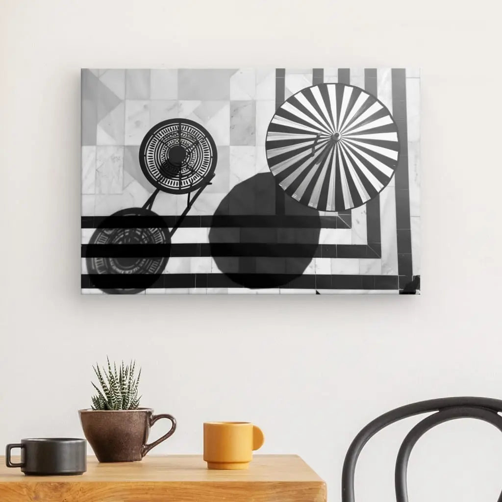 Un Tableau Bord de Piscine Mural Été Noir et Blanc présentant un design géométrique. En bas, une table en bois avec trois tasses en céramique et une petite plante en pot, créant une ambiance relaxante avec une chaise noire à côté.