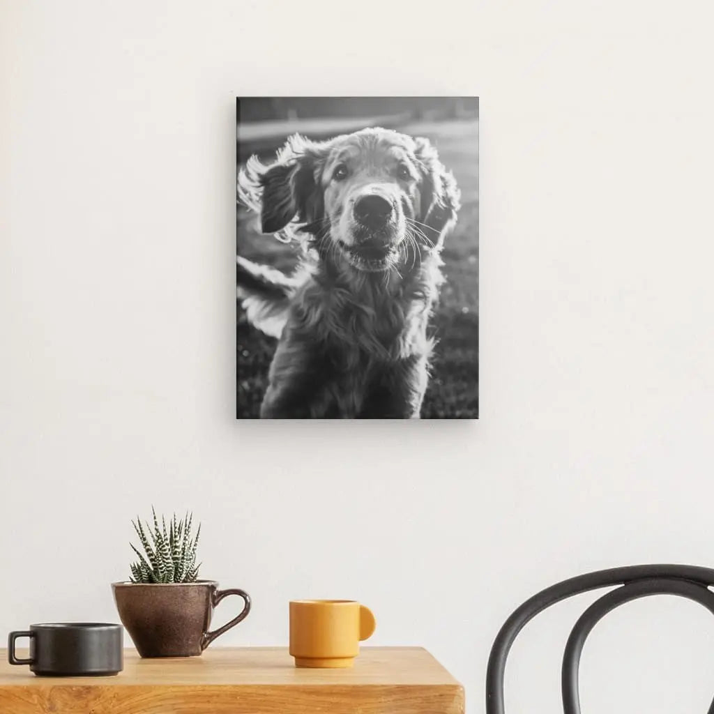 Le Tableau Golden Retriever Noir et Blanc est accroché au mur au-dessus d'une table en bois ornée d'une plante en pot et de deux tasses, à côté d'une chaise noire, créant un élégant tableau noir et blanc pour votre décoration intérieure.