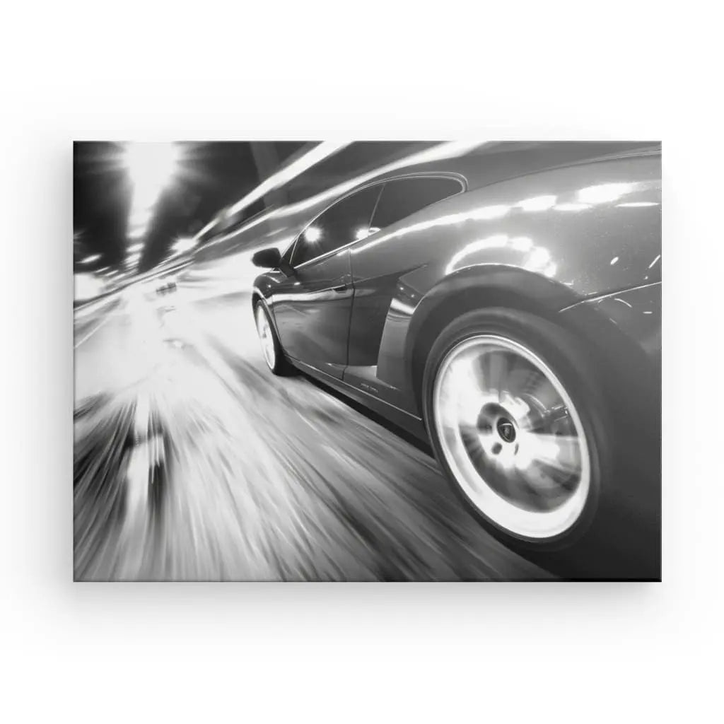 Photographie en noir et blanc d'une voiture élégante roulant à toute vitesse dans un tunnel la nuit, le Tableau Voiture Autoroute Vitesse Noir et Blanc capture une sensation de mouvement et de vitesse, évoquant une atmosphère de liberté.