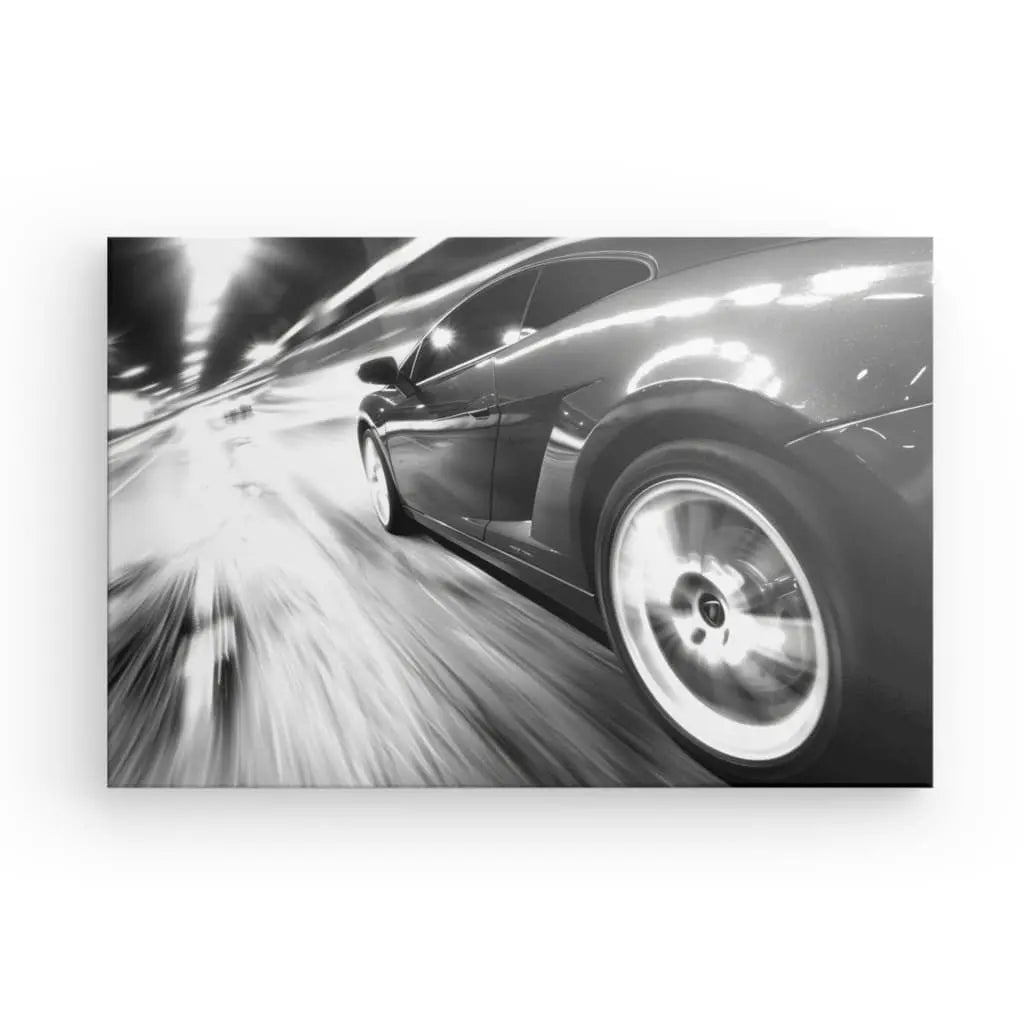 Une voiture de sport noire, représentée dans le « Tableau Voiture Autoroute Vitesse Noir et Blanc », traverse un tunnel de nuit, avec un flou de mouvement soulignant sa vitesse élevée. La scène dégage une atmosphère de liberté dans un tableau noir et blanc.