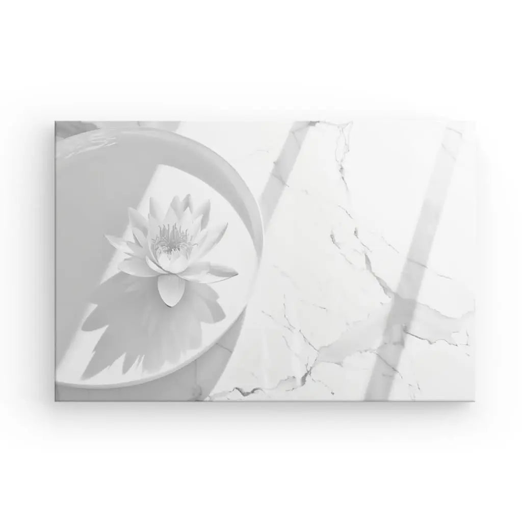 Un Tableau Zen Lotus Blanc et Gris, mettant en scène une fleur de lotus flottant dans un bol circulaire, projette une ombre sur une surface en marbre blanc veiné de gris, créant une atmosphère de décoration zen.