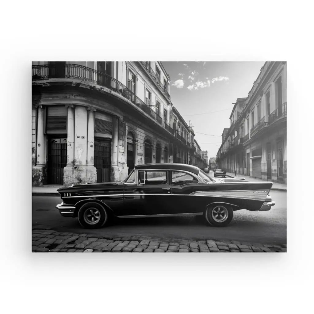 Une voiture ancienne est garée dans une rue pavée entre de vieux bâtiments dans une photo noir et blanc magnifiquement améliorée, capturant l'essence du « Tableau Voiture Cubaine Rue Noir et Blanc » avec des encres latex HP.